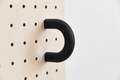 Anneau coloré noir taille M sur un pegboard en bouleau