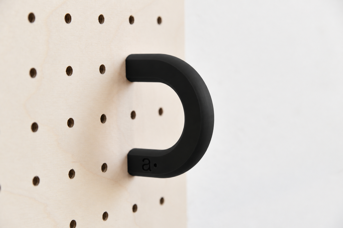 Anneau coloré noir taille M sur un pegboard en bouleau