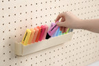 Hand nimmt einen Pastell-Textmarker aus dem kippbaren Pegboard-Halter - Aire
