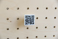 QR code personnalisé 3 × 3 cm imprimé en 3D, noir sur blanc, en gros plan sur un pegboard en bouleau