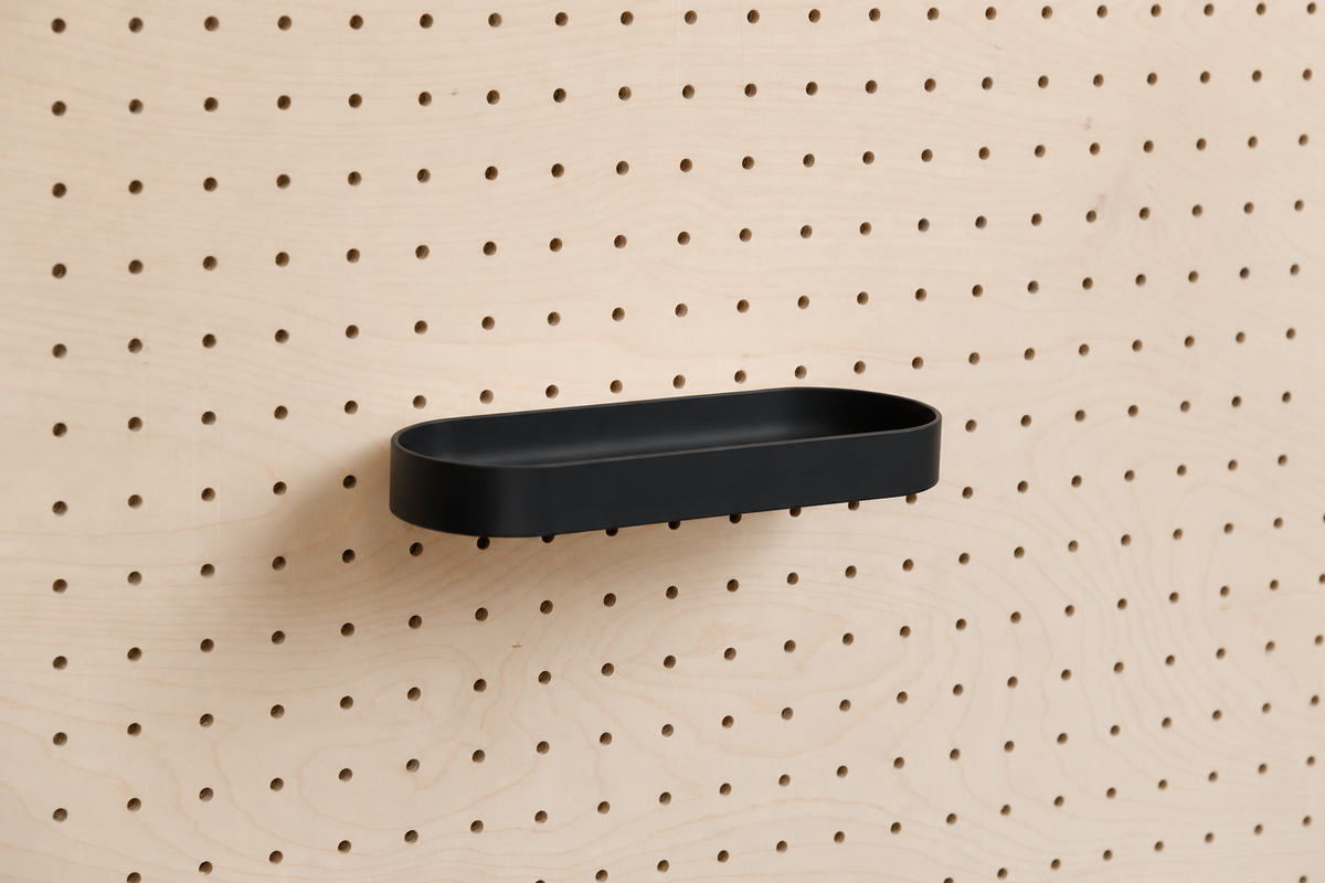 Kompaktes abgerundetes Regalbrett mit Kanten in Schwarz an einem Birken-Pegboard