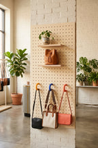 Pegboard en boutique avec anneaux colorés jaune, bleu et orange portant des sacs