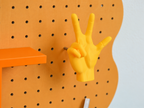 Patère main imprimée en 3D accrochée au pegboard Curves orange pastel