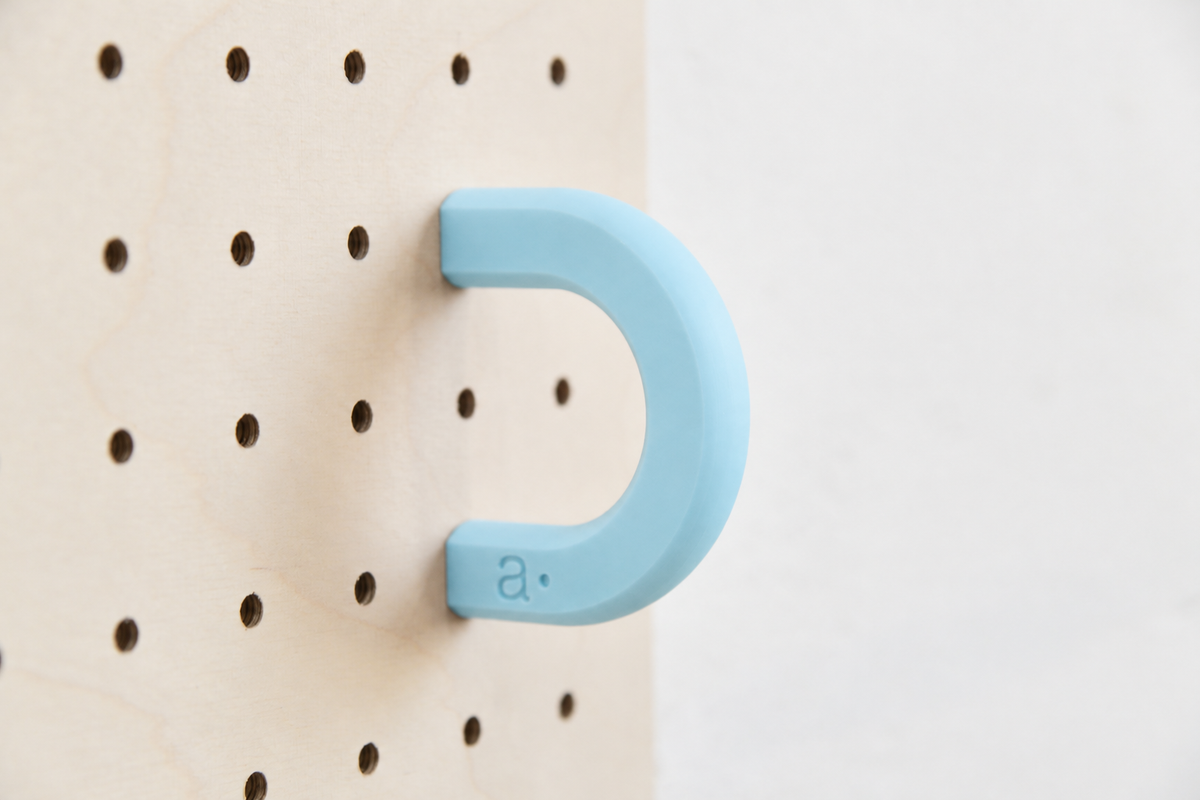Anilla de color azul cielo talla M en un pegboard de abedul
