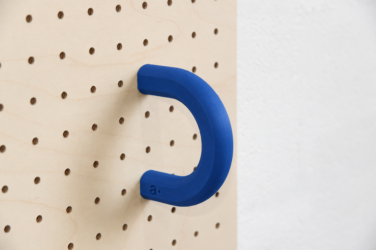 Anilla de color azul talla L en un pegboard de abedul