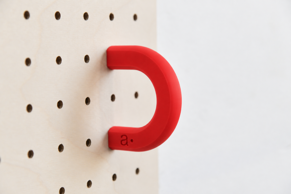 Anilla de color rojo talla M en un pegboard de abedul