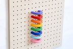 Regenbogenfarbene Ringe gestapelt an einem Pegboard