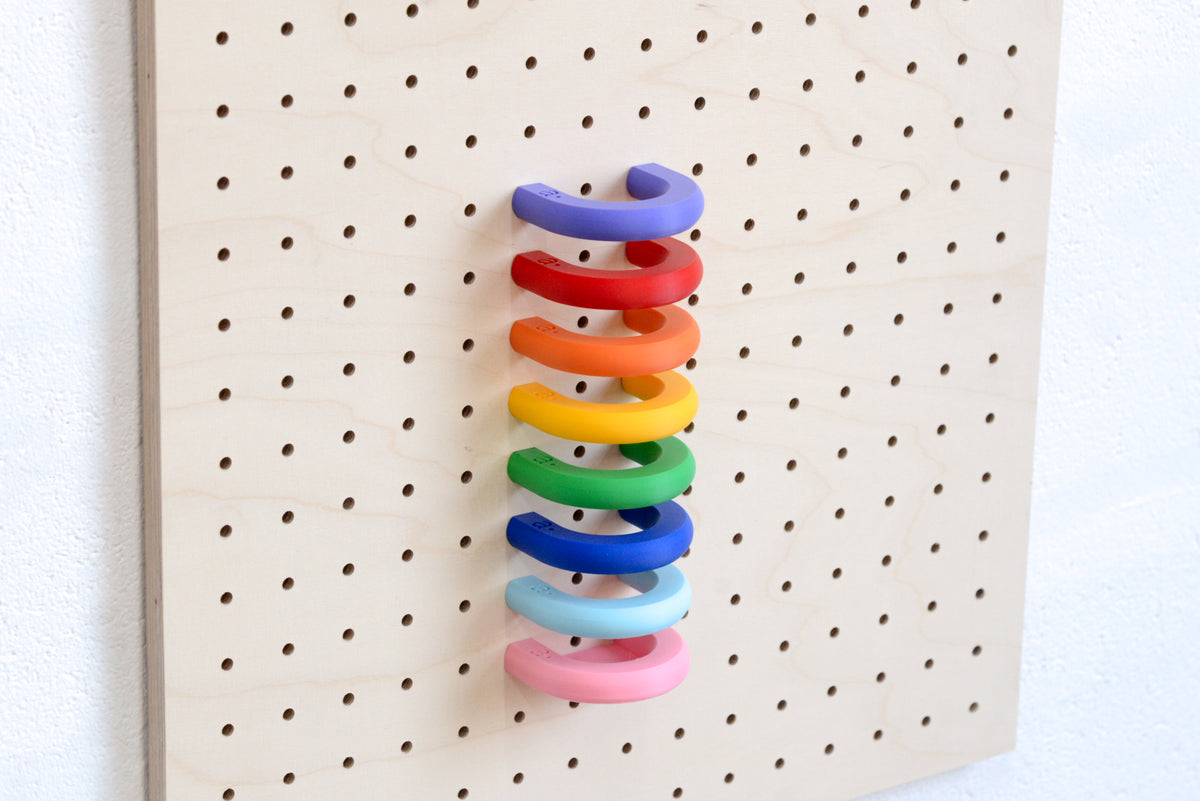 Regenbogenfarbene Ringe gestapelt an einem Pegboard
