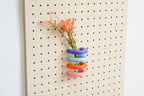 Bunte Ringe als Solifleur-Vase mit Trockenblumen am Pegboard