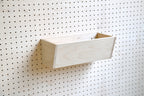 Leere Schale aus Birkenholz an einem Pegboard