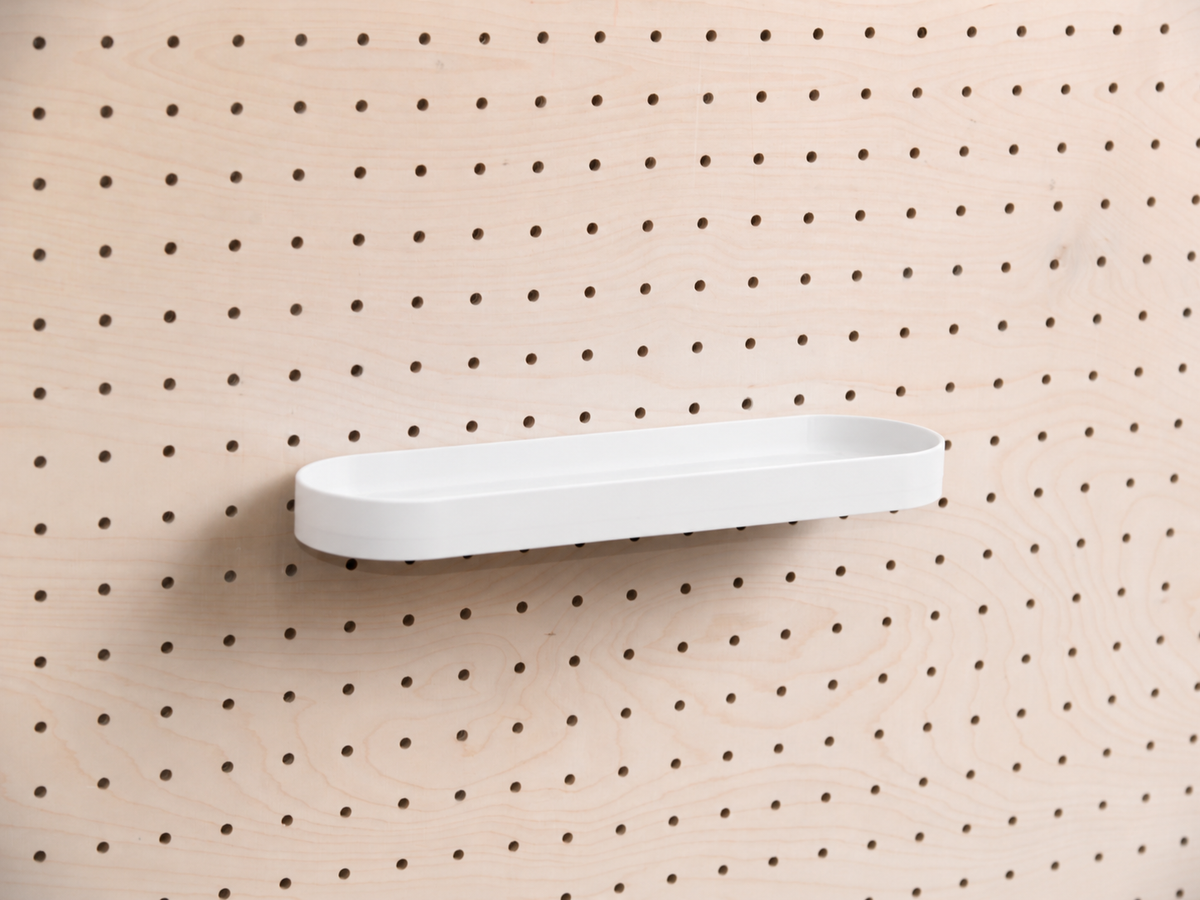 Abgerundetes Regalbrett mit Kanten in Weiß mittig an einem Birken-Pegboard, Frontansicht