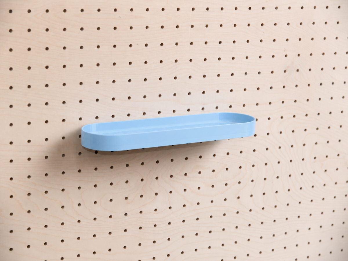 Abgerundetes Regalbrett mit Kanten in Himmelblau mittig an einem Birken-Pegboard, Frontansicht