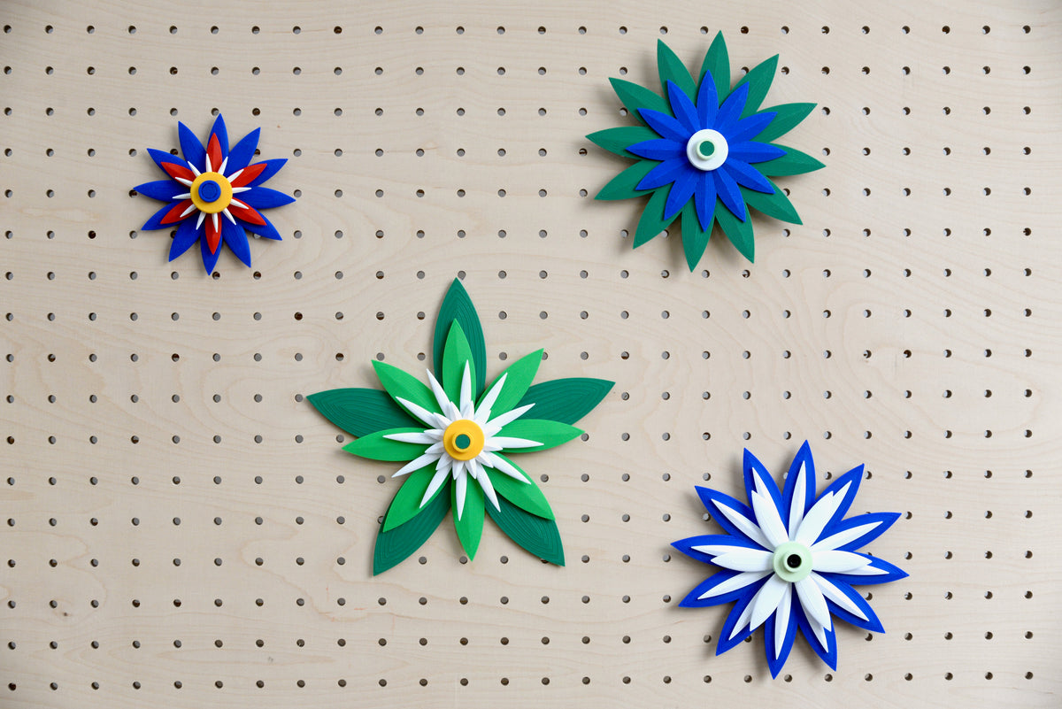 Flores decorativas modulares impresas en 3D en un pegboard de madera – Aire