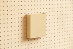 Godet porte-documents beige pour pegboard, seul au centre d'un panneau perforé en bouleau, vue de face