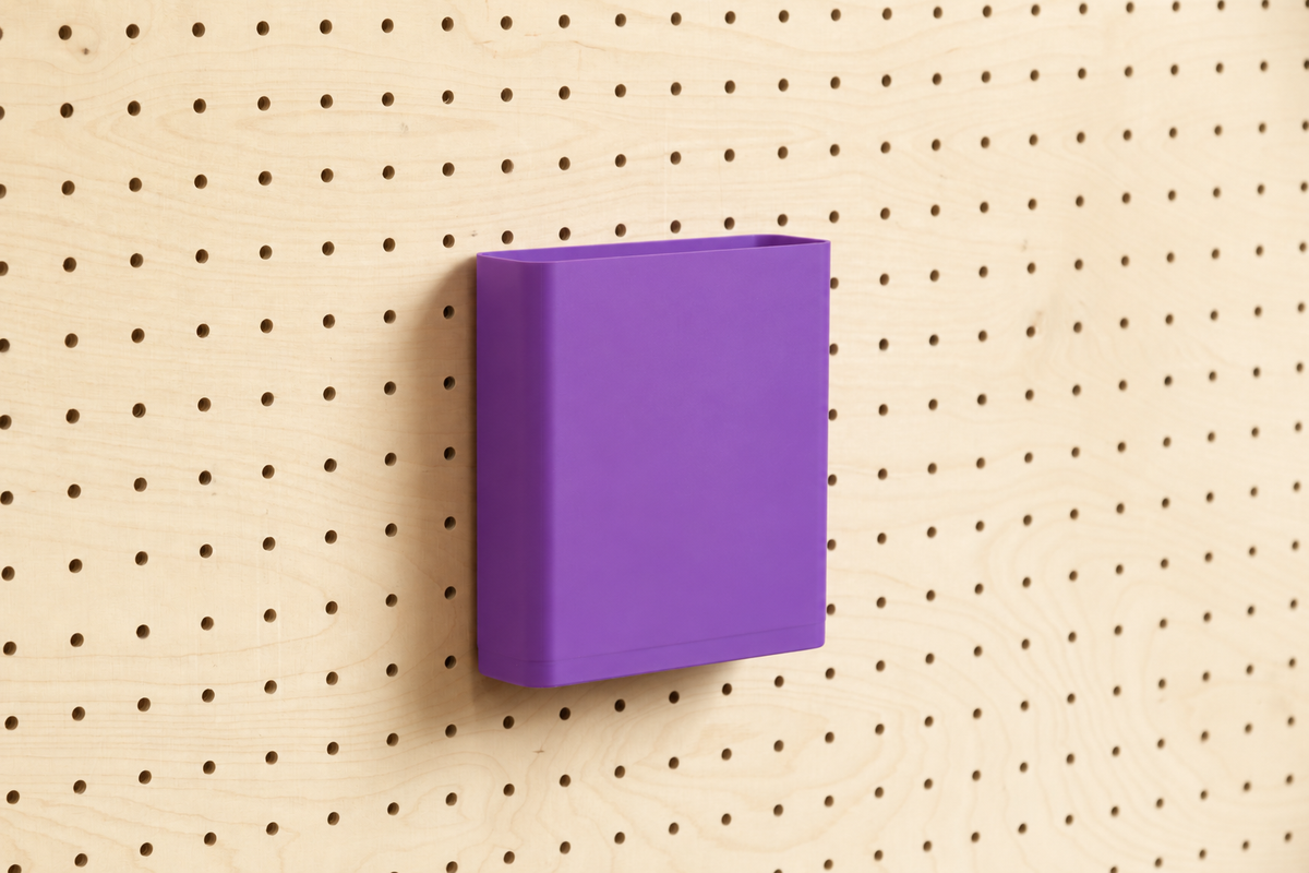 Godet porte-documents violet pour pegboard, seul au centre d'un panneau perforé en bouleau, vue de face