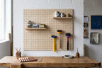 Werkstatt-Pegboard über einer Werkbank mit Hämmern an farbigen Ringen