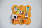 Pastellorangefarbenes Pegboard Curves mit Zeichnungen an grünen Magnetklammern