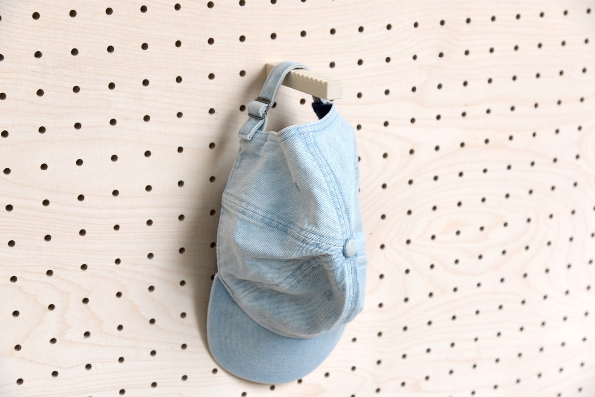 Porte-casquette mural pour panneau perforé avec une casquette bleue accrochée