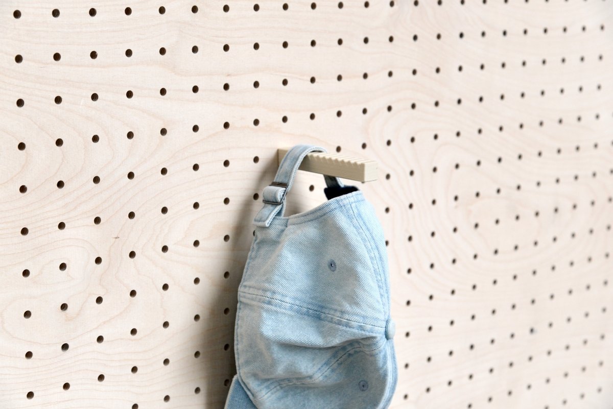 Casquette en jean suspendue par sa sangle au support casquette pour pegboard Aire