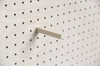 Support casquette mural Aire fixé sur un pegboard en bois – tige crantée en inox et bioplastique