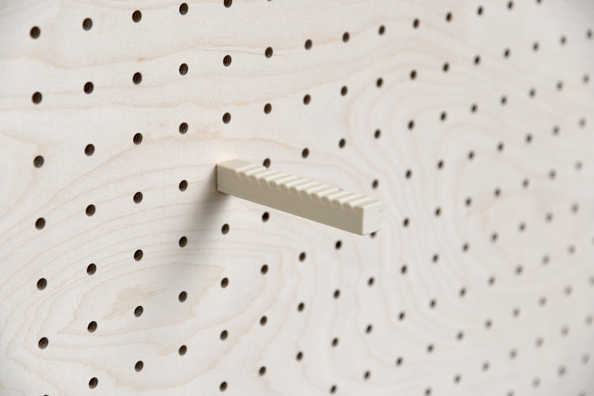 Support casquette mural Aire fixé sur un pegboard en bois – tige crantée en inox et bioplastique