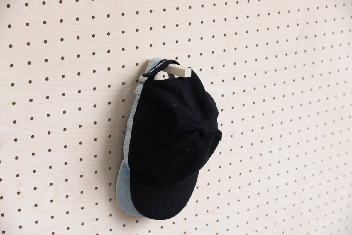 Deux casquettes superposées sur le support casquette mural Aire pour pegboard